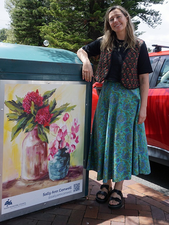 Artist with her artwork featuring flowers in vases