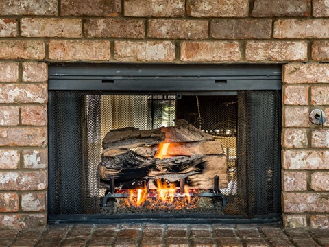 Fire place inside home with brick surrounding the black case.