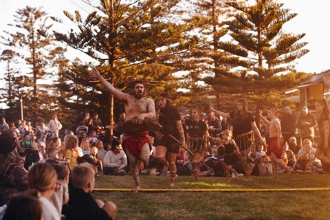 Indigenous dancers at event with crowd in background